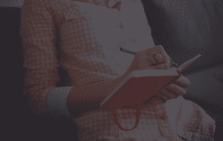 Lady writing a blog in a notepad